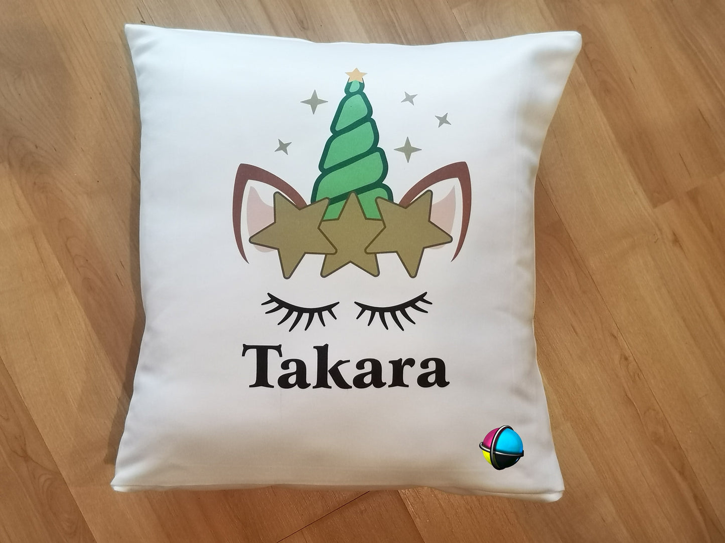 White pillow with a unicorn design and 'name' text