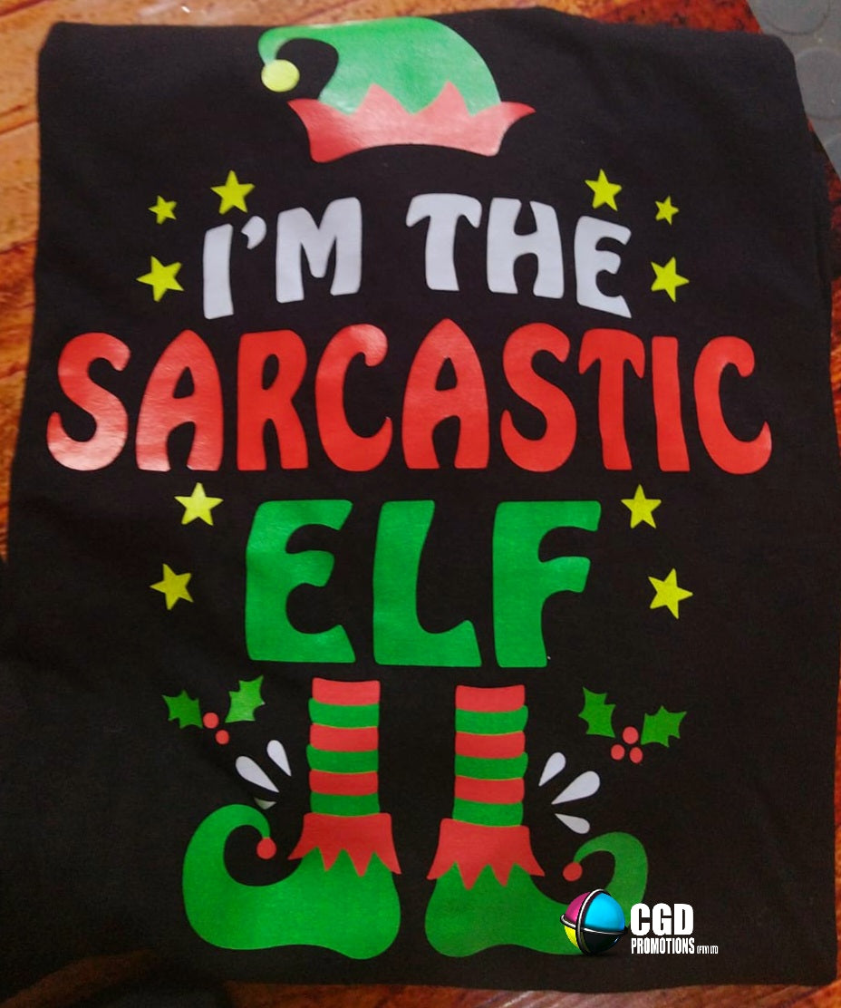 "Custom 'I'm the Elf' Christmas shirts in unisex, ladies' fitted, and kids' sizes, featuring personalized elf titles for each family member on soft, high-quality fabric." I am the sarcastic elf