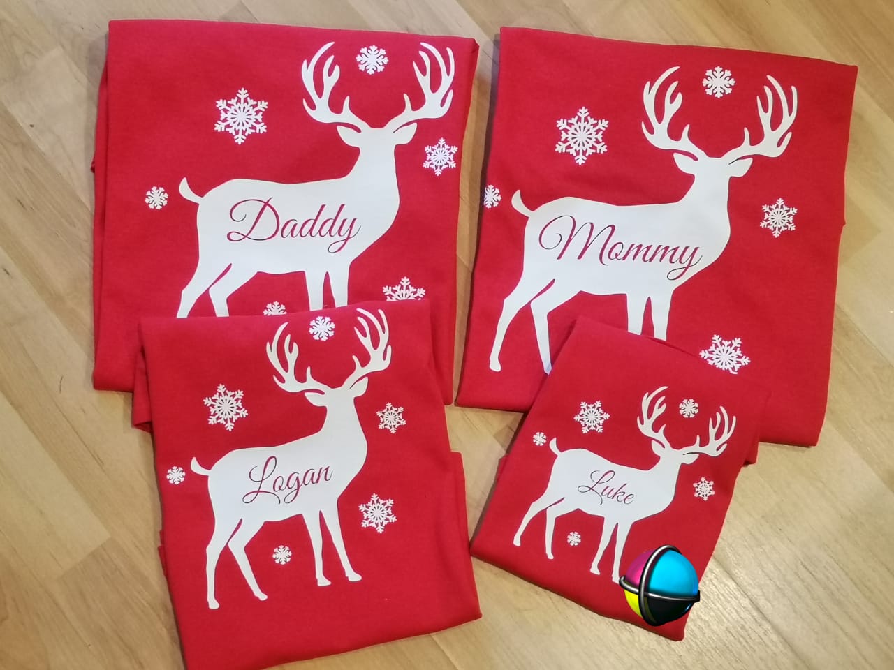 “Family of four wearing matching Christmas white reindeer shirts – unisex adult, ladies fitted, and kids tees”
